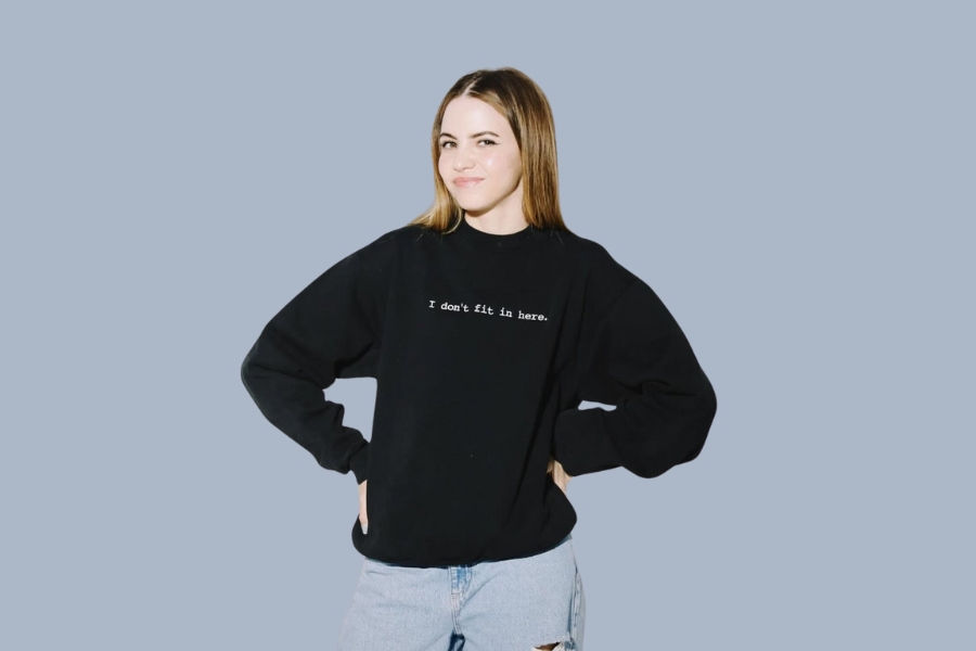 Bobbi Althoff wearing a black sweatshirt with text, standing confidently with hands on hips