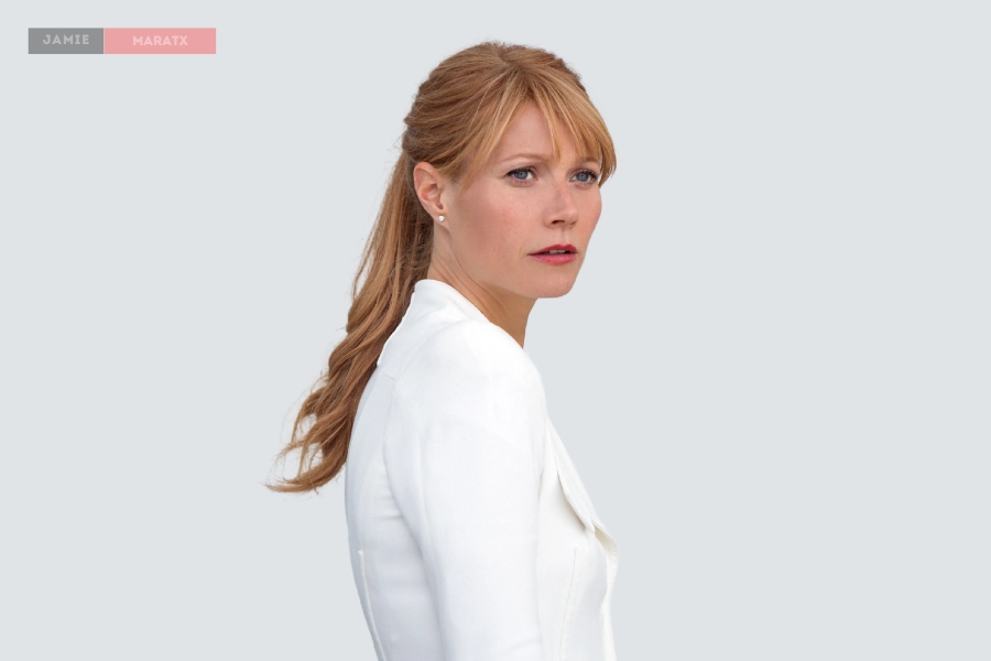 A woman with light brown hair tied in a ponytail, wearing a white blazer, looking to the side with a serious expression against a neutral background.